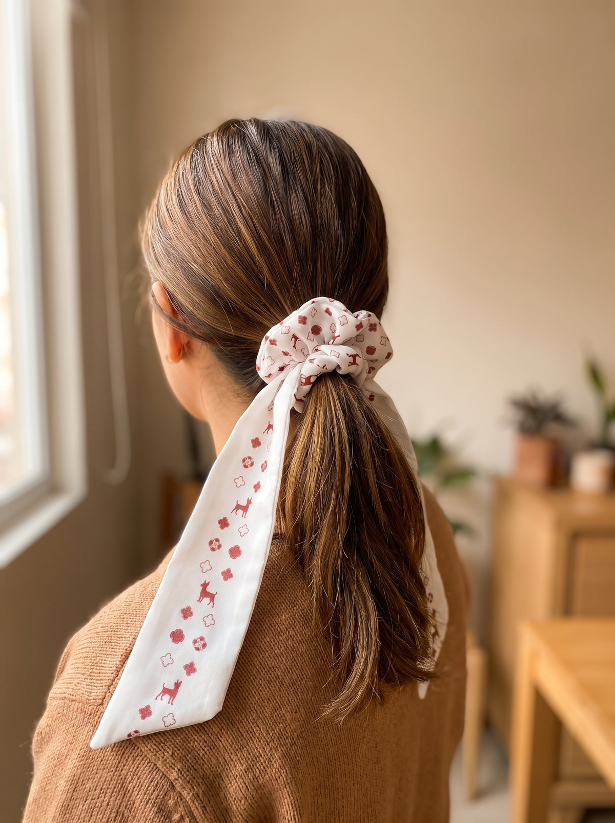 Mujer con scrunchie blanco de Pinscher en cola de caballo