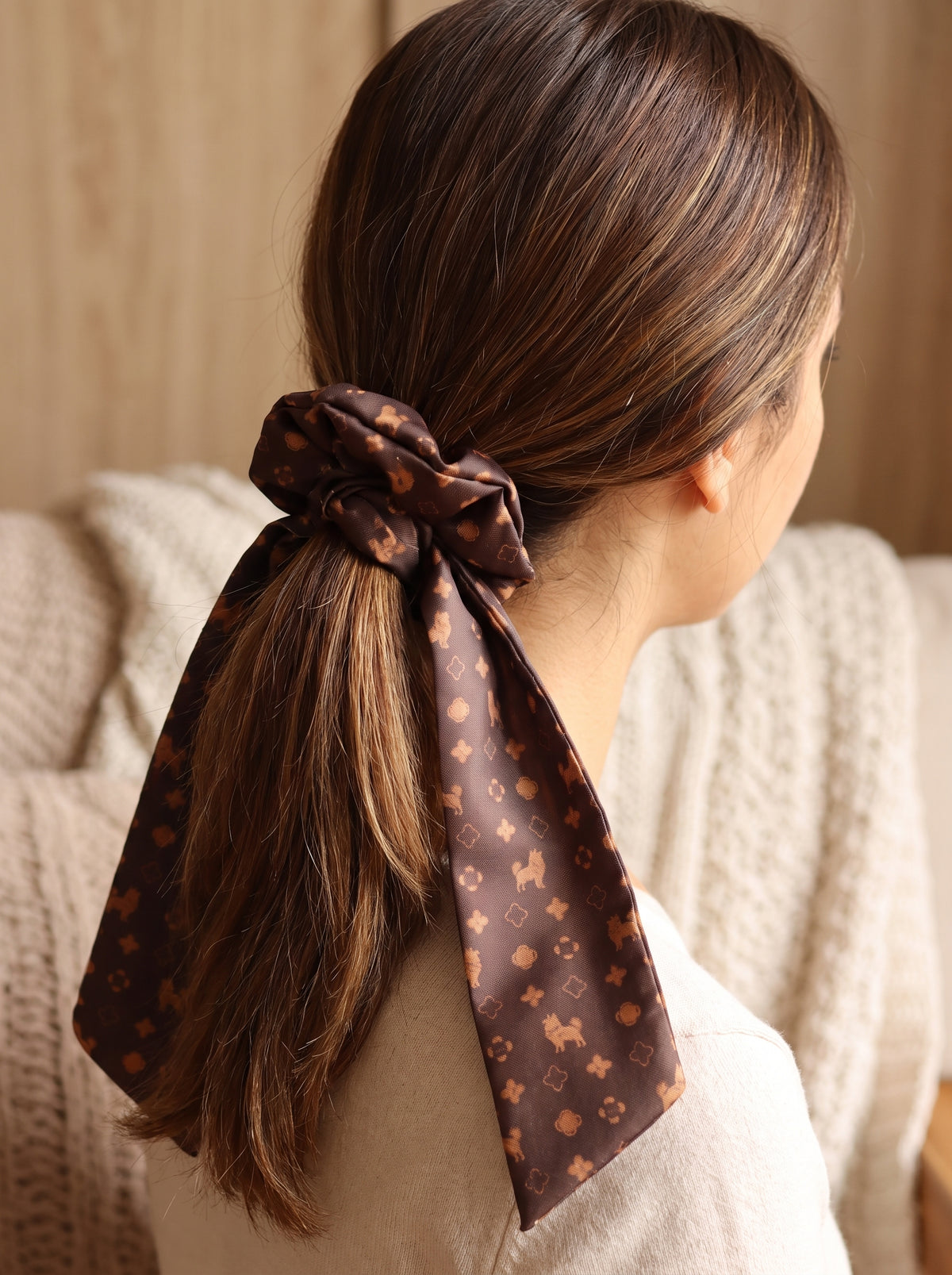Mujer con scrunchie chocolate de Pomerania en cola de caballo