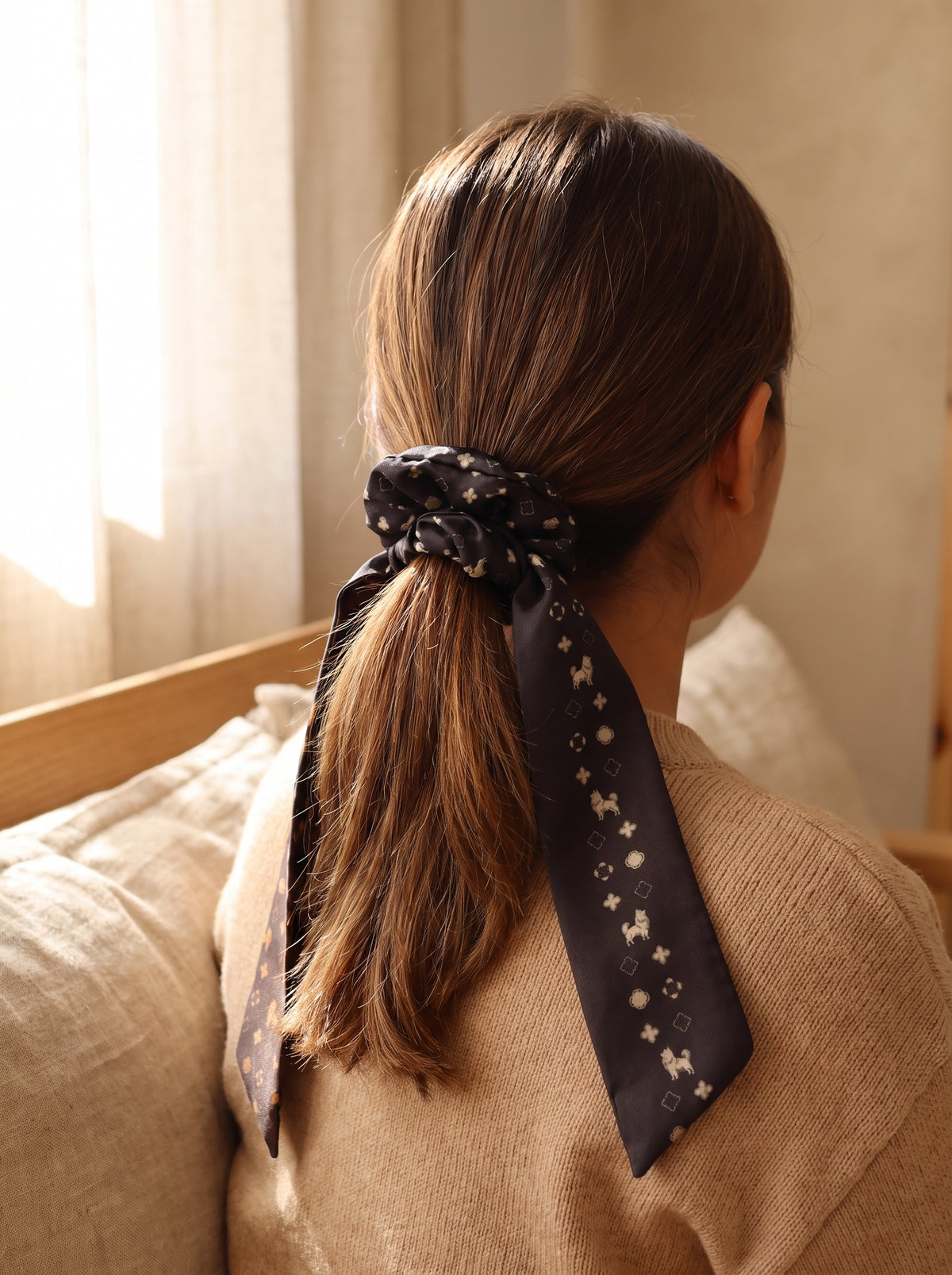 Mujer con scrunchie negro de Pomerania en cola de caballo
